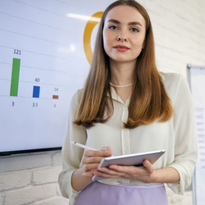 Modern young business woman having leading a presentation while using the wealth of technology to explain a statistic in a board room